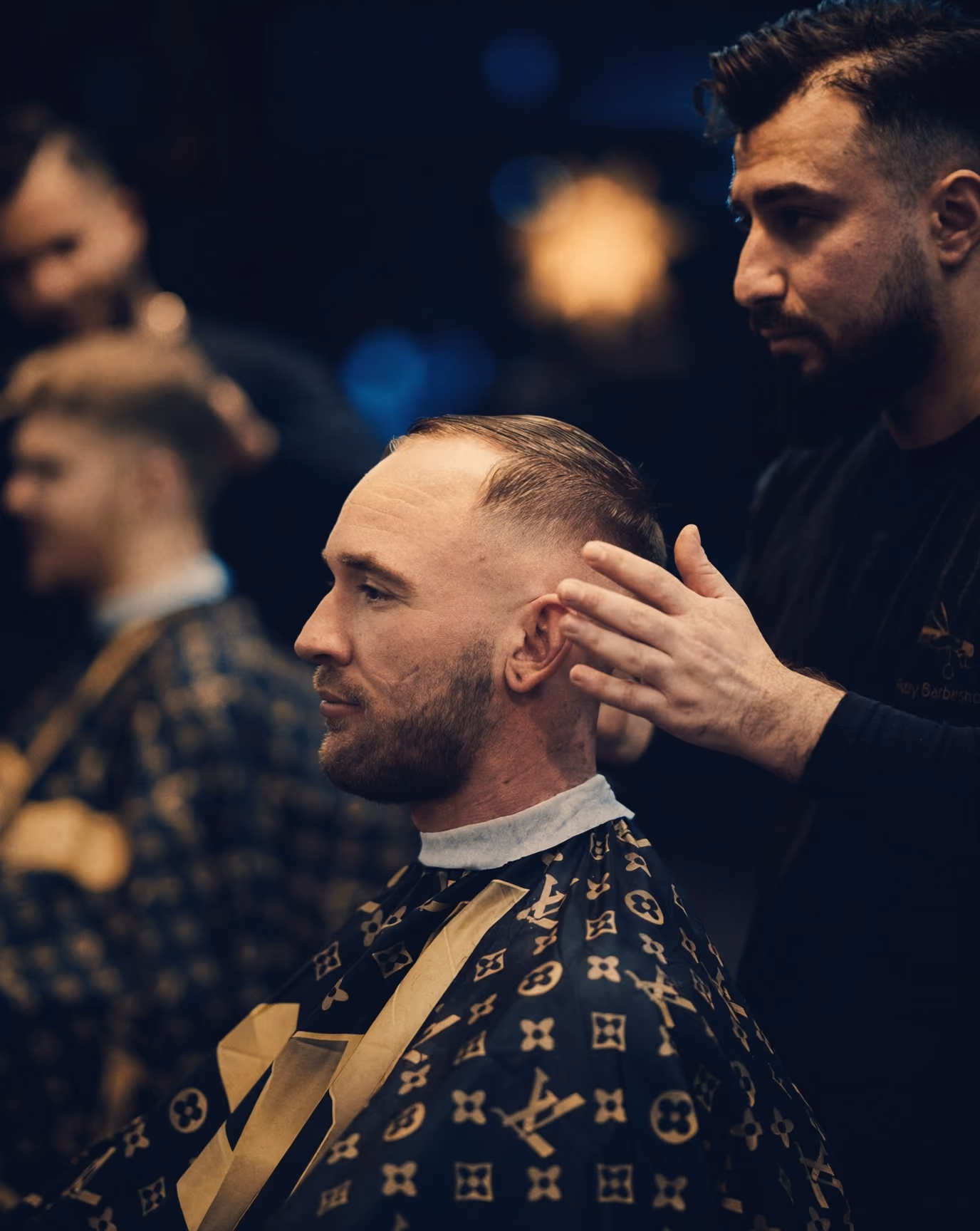 Barberare stylar en kunds nyklippta hår