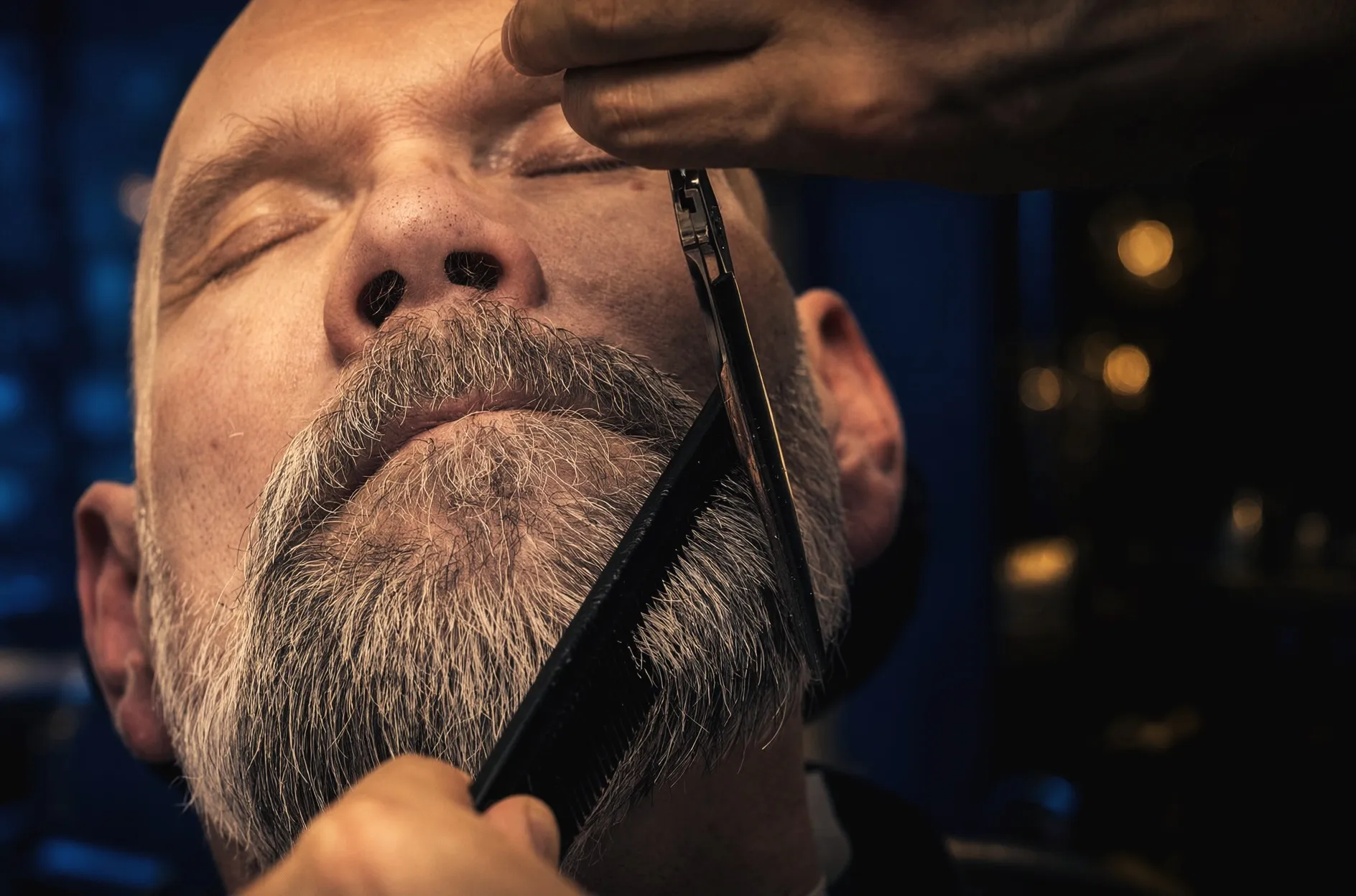 Barberare formar ett grått skägg med sax och kam